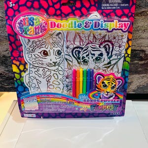 May include: A Lisa Frank Doodle & Display art kit. The package features a pink and blue leopard print design. The kit includes Sasha & Shanti art, 6 designer markers, and adhesive tape. A bonus puzzle is also included.