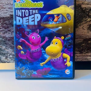 May include: DVD case for "The Backyardigans: Into the Deep." The cover shows a yellow submarine with animated characters, two mermaid-like creatures, and the title text in blue and white. The background is a vibrant underwater scene.