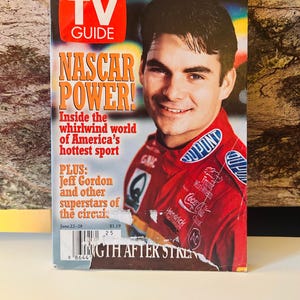 Puede incluir: Una revista TV Guide vintage con el titular "NASCAR POWER!" y una foto de un hombre con un traje de carreras rojo. La portada también presenta el logotipo de TV Guide y el texto "SPECIAL COLLECTOR'S EDITION". La revista es un artículo de colección.