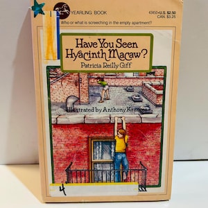 May include: A vintage paperback book titled "Have You Seen Hyacinth Macaw?" by Patricia Reilly Giff. The cover features an illustration of a child hanging from a balcony. The book has a beige cover with a green and white title box.