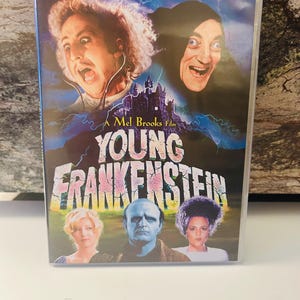 May include: DVD of the movie "Young Frankenstein" with a colorful cover. The cover features images of the actors, a castle, and the movie title. The text reads "The funniest comedy of all time!" and "A Mel Brooks Film."