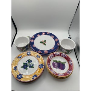 Peut inclure: Ensemble de quatre assiettes en céramique peintes à la main avec des motifs floraux et fruités. Les assiettes présentent un motif floral bleu et blanc, un motif floral jaune et bleu, un motif floral rouge et blanc et un motif floral jaune et rouge avec des prunes violettes.