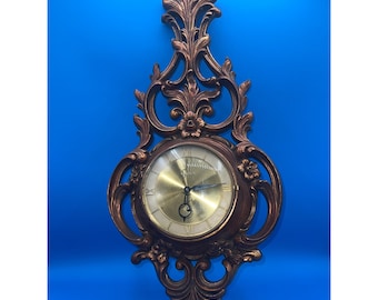 Vintage MCM Syroco Regency Gold 8 day wallclock with key 22.5 in L x 10in W