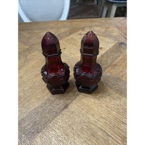 Peut inclure: Une paire de salières et poivrières vintage en verre rouge avec un motif texturé.