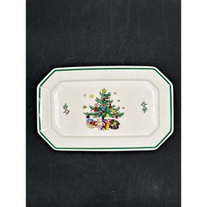 Puede incluir: Plato rectangular blanco con borde verde. El centro presenta un árbol de Navidad decorado con adornos y regalos. Pequeñas ramitas de acebo a ambos lados del árbol. Un plato festivo para servir.