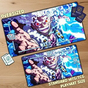 May include: Two playmats featuring a vibrant anime character with white hair and red eyes, surrounded by blue energy. The oversized mat measures 80cm x 40cm, while the standard size is 60cm x 35cm. Includes One Piece card art.