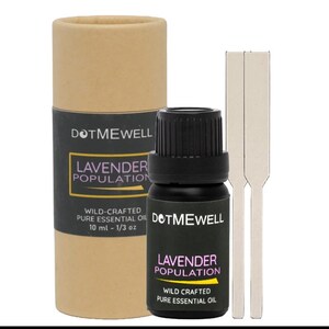 May include: A brown cardboard tube with a black label that reads "DOTMEWELL LAVENDER POPULATION WILD-CRAFTED PURE ESSENTIAL OIL 10 ml - 1/3 oz". A small black glass bottle with a black cap and a white label that reads "DOTMEWELL LAVENDER POPULATION WILD CRAFTED PURE ESSENTIAL OIL" is next to the tube. Two white wooden sticks are next to the bottle.