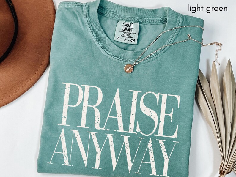 May include: A handmade wooden sign with the text "Welcome" in a whimsical font. The sign is painted white with a distressed finish, and features a decorative floral design in shades of pink and green. It is designed for indoor or outdoor use.