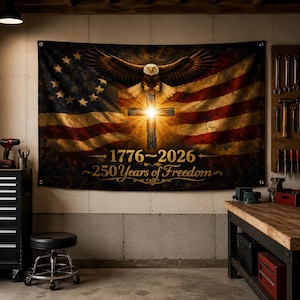 May include: A rectangular wall tapestry featuring a vintage American flag with a circle of thirteen stars, a central glowing wooden cross, and a bald eagle with wings spread. The text reads 1776-2026 and 250 Years of Freedom in gold lettering.