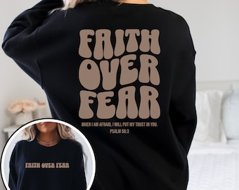 Puede incluir: Sudadera negra con el texto "FAITH OVER FEAR" en fuente retro marrón. El texto "WHEN I AM AFRAID, I WILL PUT MY TRUST IN YOU. PSALM 56:3" está impreso debajo en una fuente más pequeña.