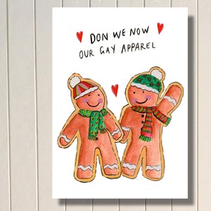 May include: A printable greeting card featuring two gingerbread people wearing winter hats and scarves. The card says "Don we now our gay apparel".