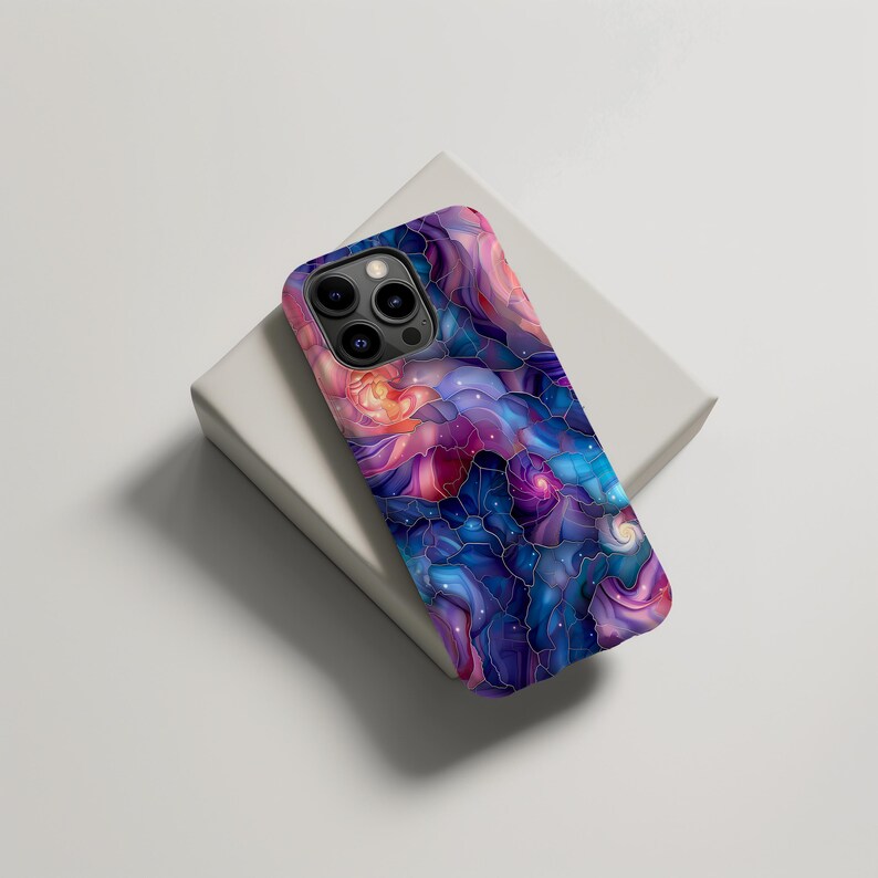 May include: A phone case with a colorful abstract design featuring swirling patterns in shades of blue, purple, pink, and white. The design resembles a galaxy or nebula.