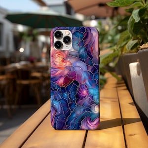 May include: A phone case with a colorful abstract design featuring swirling patterns in shades of blue, purple, pink, and orange. The design resembles stained glass with a galaxy-like effect.