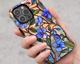 May include: A smartphone case featuring a stained glass pattern with vibrant blue flowers, green leaves, and dark brown stems against a soft peach and cream background. The design covers the back of the device, including the camera lens cutout area.