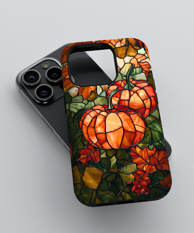 Puede incluir: Una funda de tel&eacute;fono con un dise&ntilde;o de vitral con calabazas y hojas en tonos naranja, verde y marr&oacute;n.