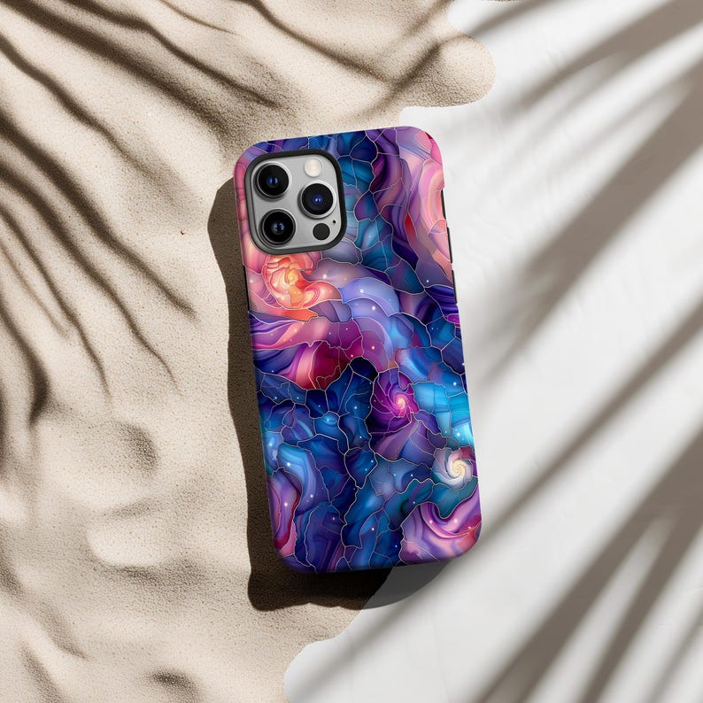 May include: A phone case with a colorful abstract design featuring swirling patterns in shades of blue, purple, pink, and orange. The design resembles a galaxy or nebula with stars and swirls.