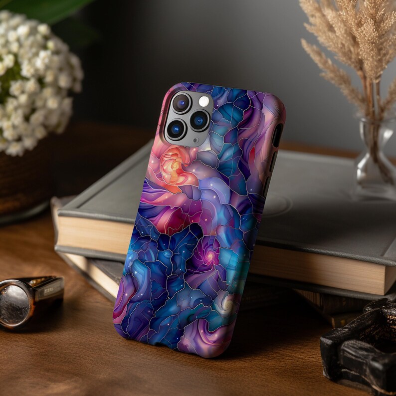 May include: A phone case with a colorful abstract design featuring swirling patterns in shades of purple, blue, pink, and white. The case has a camera cutout and a black border.