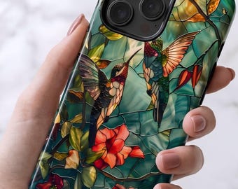 May include: A smartphone case featuring a stained glass style design with two hummingbirds in flight, surrounded by vibrant red flowers and green foliage. The artwork uses dark outlines to separate the colorful segments of the pattern.