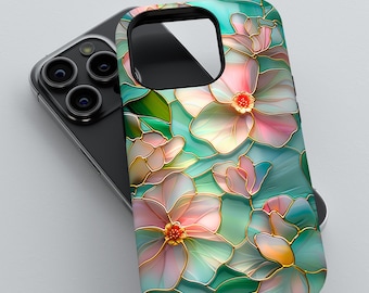 Può includere: Custodia per telefono con design floreale nei toni del rosa, verde e oro. La custodia è posizionata su uno smartphone nero, evidenziando il design e la vestibilità della custodia. Presenta un motivo floreale decorativo.