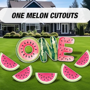 May include: Watermelon-themed yard decorations spelling out "ONE" with additional watermelon slices. The decorations are pink and green with black seeds.