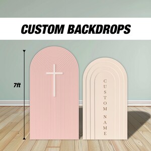 Pode incluir: Dois fundos personalizados, um rosa com uma cruz branca, o outro bege com a palavra "CUSTOM NAME" na vertical. O fundo rosa tem 2,13 m de altura. Ambos têm um topo arqueado e uma textura canelada.