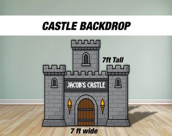 Może przedstawiać: Szare tło z zamkiem z kreskówki z napisem "CASTLE BACKDROP" u góry. Zamek ma 213 cm wysokości i 213 cm szerokości, z napisem "JACOB'S CASTLE". Zamek ma brązowe drzwi i dwie pochodnie.