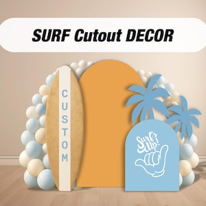 Op de afbeelding: Een decoratieve surf-thema uitgesneden set. Inclusief een houten surfboard met de tekst "CUSTOM", een oranje boog, een blauw bord met "Surf's Up!" en een handgebaar, en blauwe palmboom uitsparingen. Ballonnen op de achtergrond.
