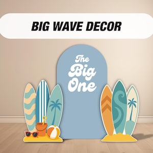 May include: Beach-themed party decorations featuring surfboards, a beach ball, sunglasses, and a sand bucket. The decorations include a large blue arch with the text "The Big One" and a banner that reads "BIG WAVE DECOR".