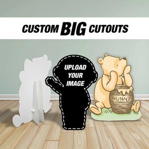May include: Custom big cutouts are shown in the image. The image shows a white cutout, a black cutout with the text "UPLOAD YOUR IMAGE", and a Winnie the Pooh cutout with a honey pot. The cutouts are on a wooden floor.