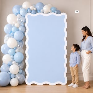 May include: A 7ft tall light blue scalloped backdrop panel featuring a vertical balloon garland in shades of light blue, white, and clear. The rectangular board has a wavy edge and a solid light blue surface, standing upright on a floor.