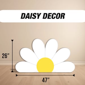 Op de afbeelding: Een grote witte madeliefjes-uitsparing met een geel centrum. De madeliefjes is 26 inch hoog en 47 inch breed. "DAISY DECOR" staat in zwarte tekst op een witte banner.