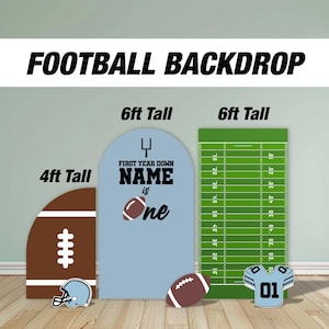 Könnte beinhalten: Drei Fußball-Hintergrundbilder für eine erste Geburtstagsfeier. Die Hintergrundfolie links ist braun und weiß mit einem Fußball-Design und misst 1,2 Meter hoch. Die mittlere Hintergrundfolie ist hellblau mit dem Text "First Year Down NAME is One" und misst 1,8 Meter hoch. Die Hintergrundfolie rechts ist grün mit weißen Yard-Linien und misst 1,8 Meter hoch.