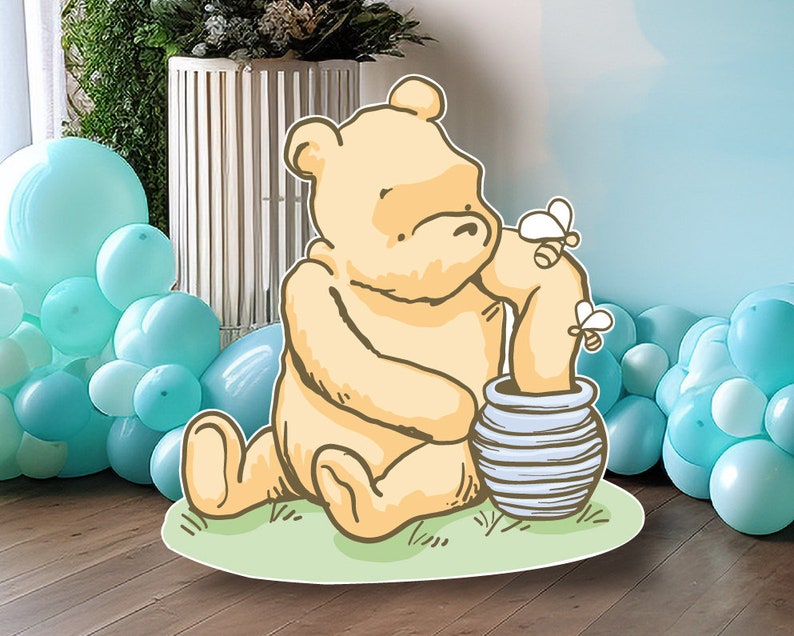 Puede incluir: Un oso de dibujos animados amarillo sentado en un parche de hierba verde, sosteniendo un tarro de miel a rayas azul y blanco. Dos abejas amarillas vuelan alrededor del oso.