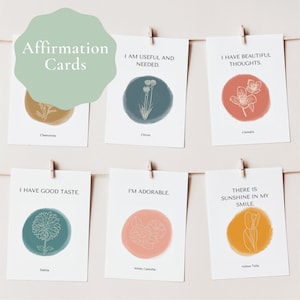 May include: Six affirmation cards with floral illustrations and positive messages. The cards are hung on a string with clothespins. The messages include "I am useful and needed", "I have beautiful thoughts", "I have good taste", "I'm adorable", and "There is sunshine in my smile".