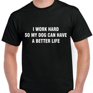 以下が含まれることがあります： 白い文字で「I WORK HARD SO MY DOG CAN HAVE A BETTER LIFE」と書かれた黒いクルーネックTシャツ。 このシャツは柔らかい素材でできており、カジュアルウェアに適しています。