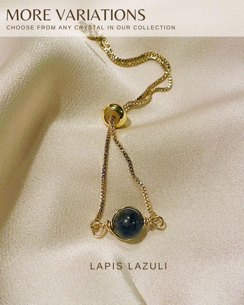 Op de afbeelding: Een goudkleurige verstelbare armband met een donkerblauwe lapis lazuli steen. De armband heeft een fijne ketting en een schuifkraal voor aanpassing. De tekst "MORE VARIATIONS" en "LAPIS LAZULI" zijn zichtbaar.