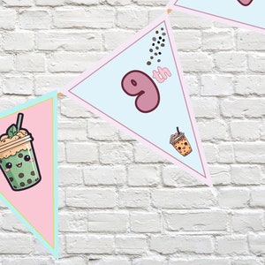 Könnte beinhalten: Ein rosa-blaues Dreiecksbanner mit einem Cartoon-Bubble-Tea-Becher und der Zahl 9 mit dem Wort "th" daneben. Das Banner ist mit braunen Punkten verziert.