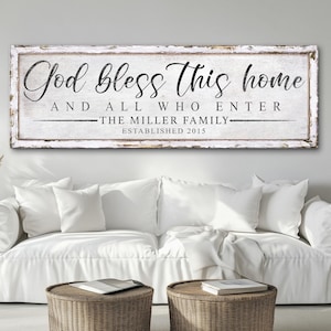 Op de afbeelding: Een wit houten bord met zwarte tekst die "God bless this home and all who enter - The Miller Family - Established 2015" luidt.