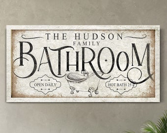 May include: A vintage-style bathroom sign with the text "The Hudson Family Bathroom" in black lettering on a white background. The sign also features a black and white illustration of a bathtub with the text "Open Daily" and "Hot Bath 25¢" on either side.