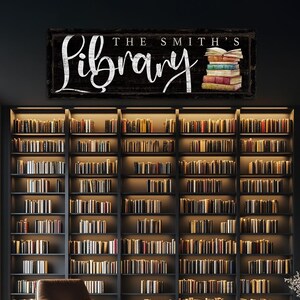 Op de afbeelding: Een zwart houten bord met witte letters met de tekst "The Smith's Library". Het bord is versierd met een stapel kleurrijke boeken.