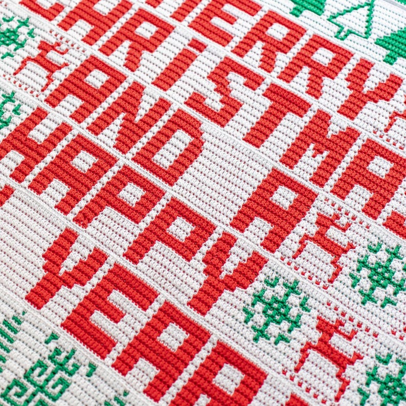 May include: A white crocheted blanket with red lettering that reads "Merry Christmas and Happy New Year".