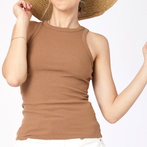 May include: A brown ribbed tank top with a scoop neck.