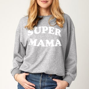 May include: A gray sweatshirt with the text "SUPER MAMA" printed in white.