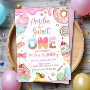 May include: A pink and white birthday invitation with the text "Amelia is a Sweet One." The invitation features illustrations of donuts, ice cream, and candy. The details include the date, time, and location of the party.