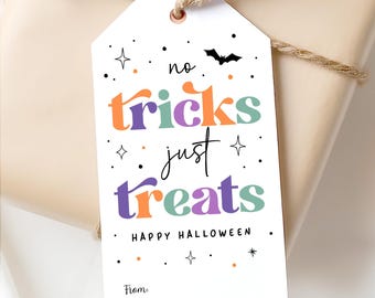 May include: A white Halloween gift tag with the text "no tricks just treats" in orange, purple, and green. The tag includes a black bat, stars, and the words "Happy Halloween". A brown twine is tied around the gift.