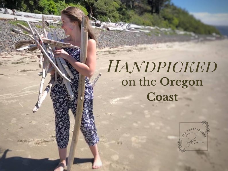 Peut inclure: Une personne tenant du bois flott&eacute; sur une plage de sable. Le texte "HANDPICKED on the Oregon Coast" est affich&eacute; en marron. L'image comprend &eacute;galement un logo pour "The Forest & Cove".