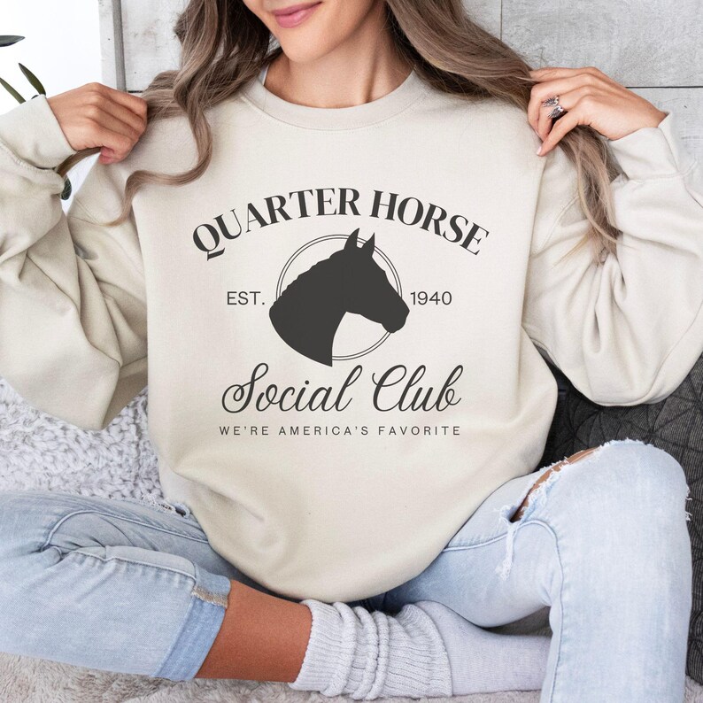 May include: A beige sweatshirt with the text "Quarter Horse Social Club" and a silhouette of a horse's head. The text "Est. 1940" is below the horse's head.