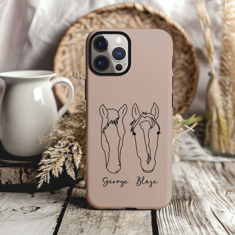 May include: A light brown phone case with a black outline of two horse heads and the names "George" and "Blaze" printed below.