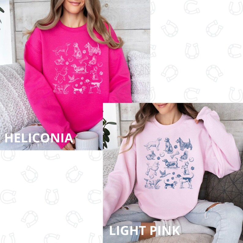 Peut inclure: Deux sweat-shirts roses avec un imprim&eacute; graphique de diff&eacute;rentes races de chiens dans un contour blanc. Le sweat-shirt de gauche est de couleur rose vif et le sweat-shirt de droite est de couleur rose clair. Le texte "Heliconia" est sous le sweat-shirt de gauche et le texte "Rose clair" est sous le sweat-shirt de droite.