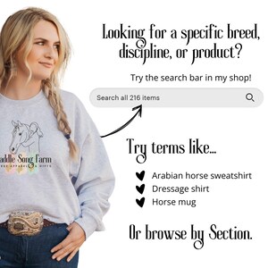 May include: A woman wearing a gray sweatshirt with a horse and rider graphic and the text "Saddle Song Farm Horse Apparel & Gifts". The text "Looking for a specific breed, discipline, or product? Try the search bar in my shop! Search all 216 items" is displayed above a search bar with a magnifying glass icon. Below the search bar, the text "Try terms like..." is displayed above a list of suggested search terms: "Arabian horse sweatshirt", "Dressage shirt", and "Horse mug". The text "Or browse by Section." is displayed below the list of search terms.